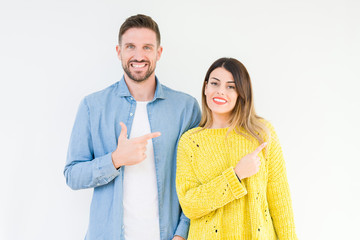 Wall Mural - Young beautiful couple togheter over isolated background cheerful with a smile of face pointing with hand and finger up to the side with happy and natural expression on face