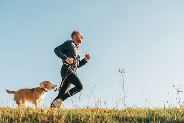 Wall Mural - sport activity with pet. canicross exercises. man runs with his beagle dog