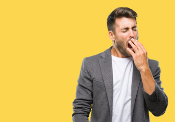 Young handsome business man over isolated background bored yawning tired covering mouth with hand. Restless and sleepiness.