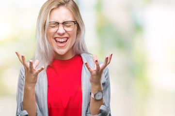 Young blonde business woman wearing fashion jacket over isolated background celebrating mad and crazy for success with arms raised and closed eyes screaming excited. Winner concept