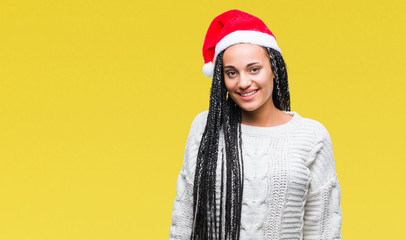 Poster - Young braided hair african american girl wearing christmas hat over isolated background with a happy and cool smile on face. Lucky person.