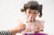 © Asada - Asian mother making nasal wash for her baby girl by flushing kid'nose with syringe and saline. An Irrigation can benefit people who have sinus problems,nasal allergies isolated on white background