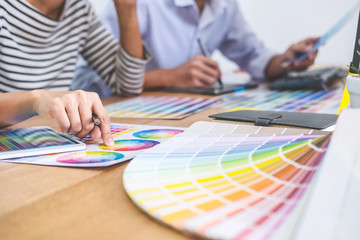 Poster - Two colleagues creative graphic designer working on color selection and drawing on graphics tablet at workplace, Color swatch samples chart for selection coloring