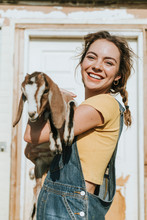 Portrait Of A Beautiful Young Woman With A Goat
