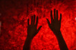 © Pixel-Shot - Female hands behind glass against red bloody background. Panic attack concept