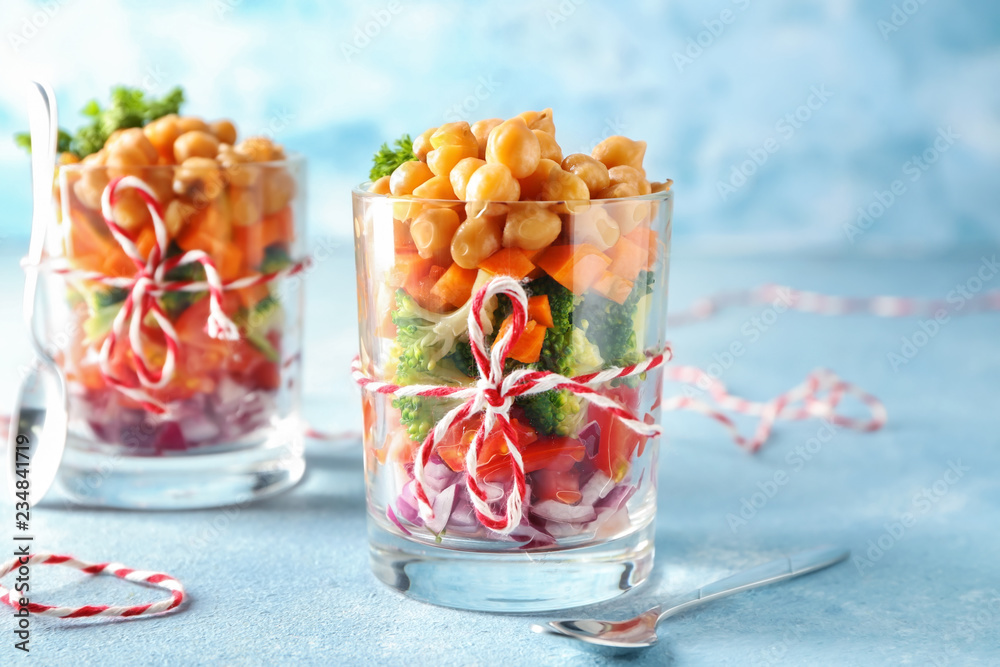 Tasty salad with chickpeas in glasses on table