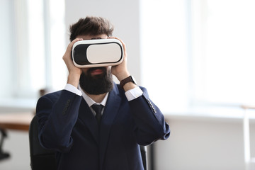 Wall Mural - Businessman wearing virtual reality glasses in office