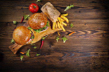 Delicious hamburgers with fries, served on wood