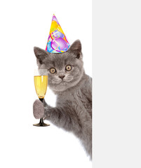 Poster - cat in birthday hat holding glass of champagne behind empty white banner. isolated on white background