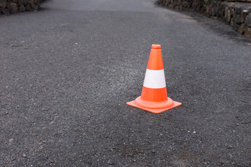 Red white road car safety cone on black asphalt