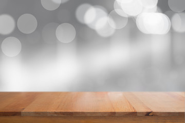Canvas Print - wooden desk with blurred light bokeh abstract background