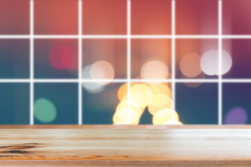 Canvas Print - wooden desk with blurred light on road in city with bokeh abstract background