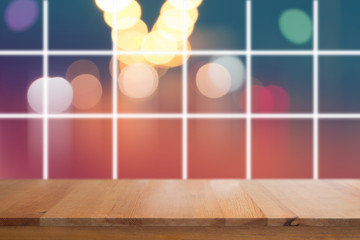 Canvas Print - wooden desk with blurred light on road in city with bokeh abstract background