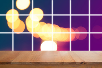 Canvas Print - wooden desk with blurred light on road in city with bokeh abstract background