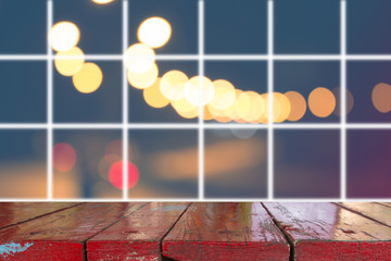 Canvas Print - wooden desk with blurred light on road in city with bokeh abstract background