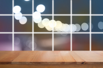 Canvas Print - wooden desk with blurred light on road in city with bokeh abstract background
