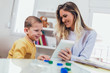 © Mediteraneo - Young mother and her son play in kids room. Funny mom and lovely child are having fun with tablet.