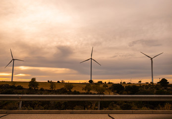 Wind power windmills and a beautiful sunset landscape. Clean and ecological energy being generated with the wind of nature through these propellers