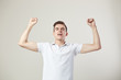 © Leika production - Elated guy dressed in a white t-shirt and jeans is on a white background in the studio