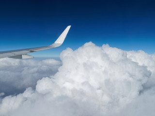 Aerial view of cloud and sky with airplane wing from airplane window ,Traveling concept.