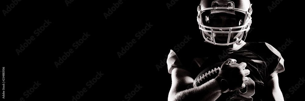 American football player in helmet holding rugby ball - obrazy, fototapety, plakaty 