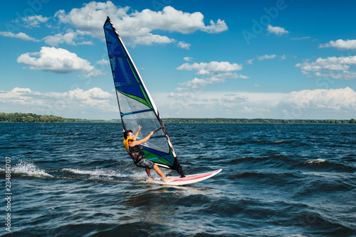 Obrazy Windsurfing  sportowiec-mezczyzna-jezdzi-na-windsurfingu-nad-falami-na-jeziorze
