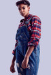 © micro - Elegant black hipster girl with short hair in a plaid shirt and denim overalls.