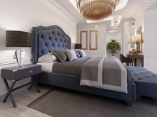 A Luxurious Bedroom In A Classic Style With Gold Elements And A Blue Bed Cloth And A Wooden Dresser And Dressing Table.