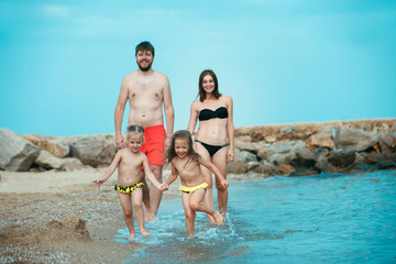 happy family enjoying walk on the sea beach. the summer, childhood, holiday, leisure, lifestyle, tra