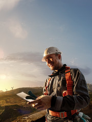 Wall Mural - happy engineer planning new project. he standing a top mount and looking in tablet. around beautiful