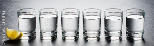 Fotografía Vodka in glass glasses. Piece of lemon. Horizontal photo