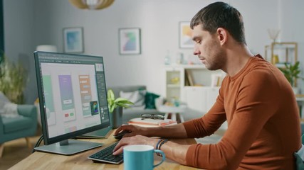 Handsome Software Engineer Works on a UX / UI Mobile App Template, Uses Personal Computer. Freelance Programmer Working from Cozy Living Room.