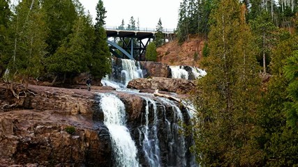 Wall Mural - Young couple exploring Gooseberry Falls State Park in Minnesota late autumn on the North Shore of Lake Superior