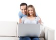 © BillionPhotos.com - Smiling Couple Using Laptop on the Couch
