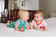 © anoushkatoronto - Group portrait of two white Caucasian cute adorable funny baby boys lying together on bed communicating and playing. Friendship childhood concept. Best friends forever. Children talking