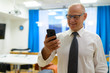 © Ranta Images - Happy Senior Businessman Using Phone In The Office