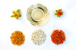 Yellow, red dried petals, inflorescences, seeds and oil of safflower against a white background. View from above. Flat lay.