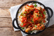 Haitian Stewed Chicken (Poule en Sauce)served with white rice in a black pan closeup. Horizontal top view