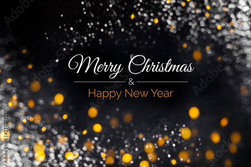 Fotografía Merry Christmas and Happy New Year card with text, yellow and white lights soft focus on black background