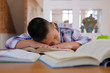 © 88studio - lazy stressed young little asian kid boy  resting sleeping on desk. child fall asleep. children tired from studying