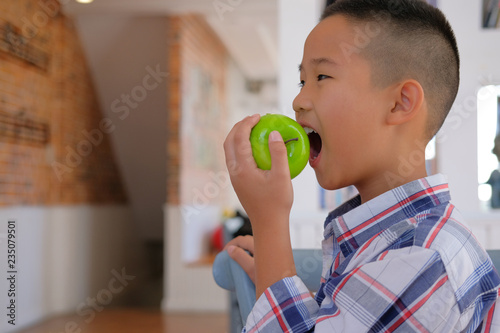 little asian kid boy child children biting eating apple. childhood ...