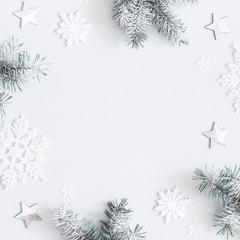 christmas composition. frame made of fir tree branches, decorations on pastel gray background. chris