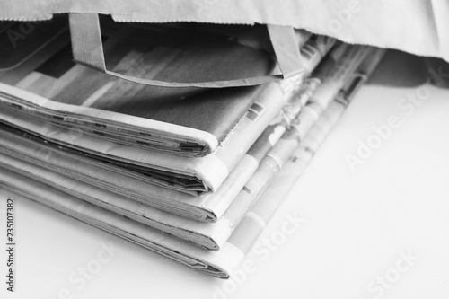 Fotografie, Obraz Stack of fresh newspapers and business magazines with latest news in paper bag l