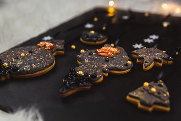 Sticker - hand painted christmas gingerbread on a black background. close-up.