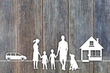 Happy family on wooden background, white paper cut concept by silhouette symbols of house, family with dog and car on wooden background in top view concept for assurance health-care insurance