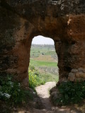 Fototapeta Mapy - View of a rural landscape through an old red stone gate in the mountains of Ronda