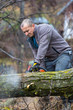 © czamfir - Forestry worker - lumberjack works with chainsaw. He cuts a big tree in forest.