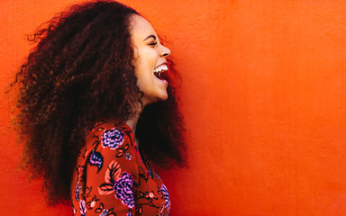 Side view of young woman in floral dress laughing