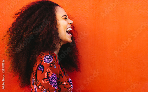Fotomural Side view of young woman in floral dress laughing