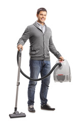 Wall Mural - Handsome young man holding a vacuum cleaner